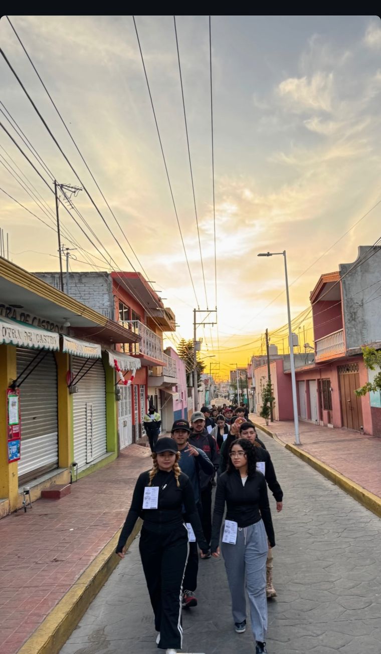 Grupo de Kilómetro Cero caminando al amanecer por las calles de Huanímaro